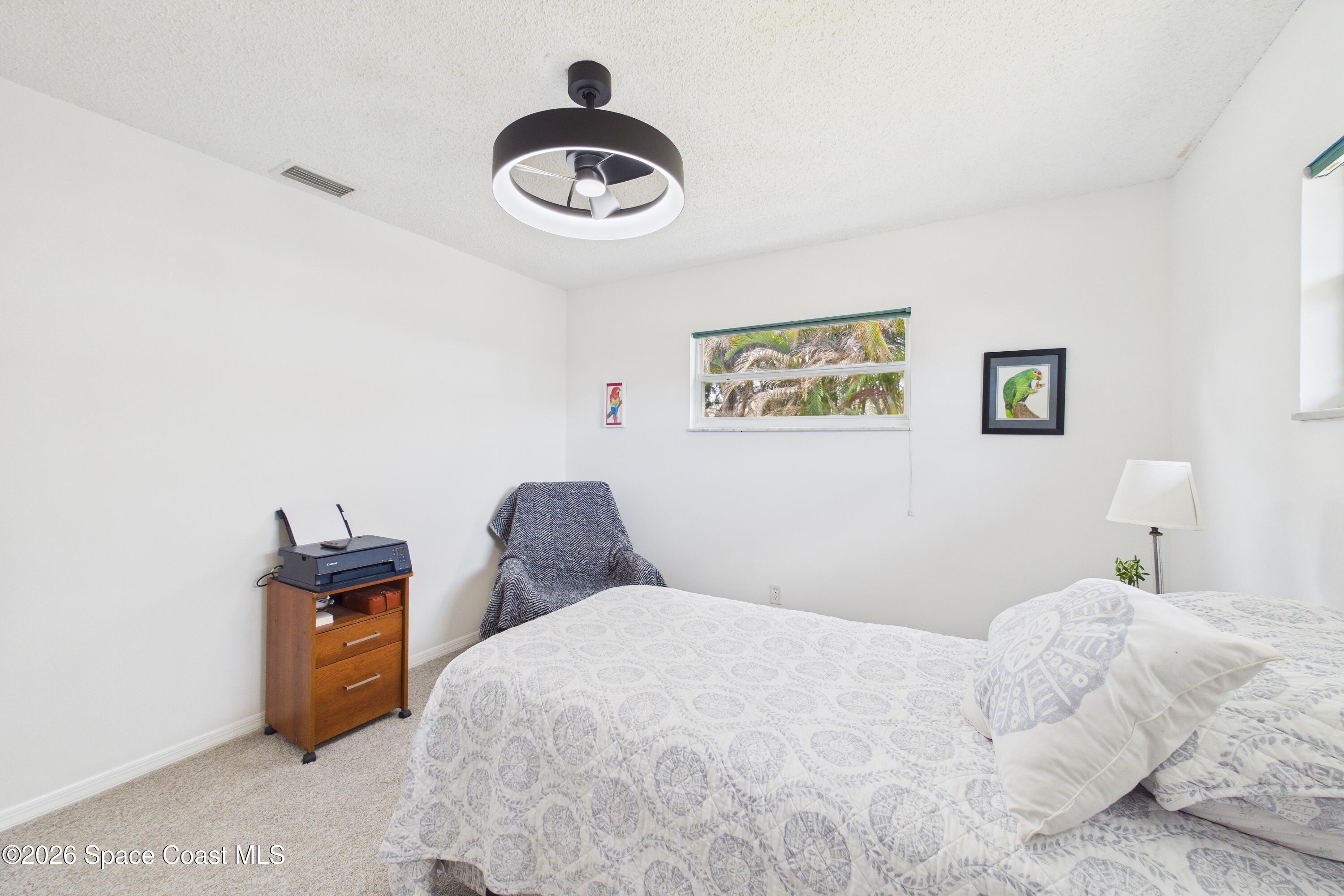 280 Coral Way West Indialantic, FL 32903 - Photo 30 of 72 a bedroom with a bed and a chandelier