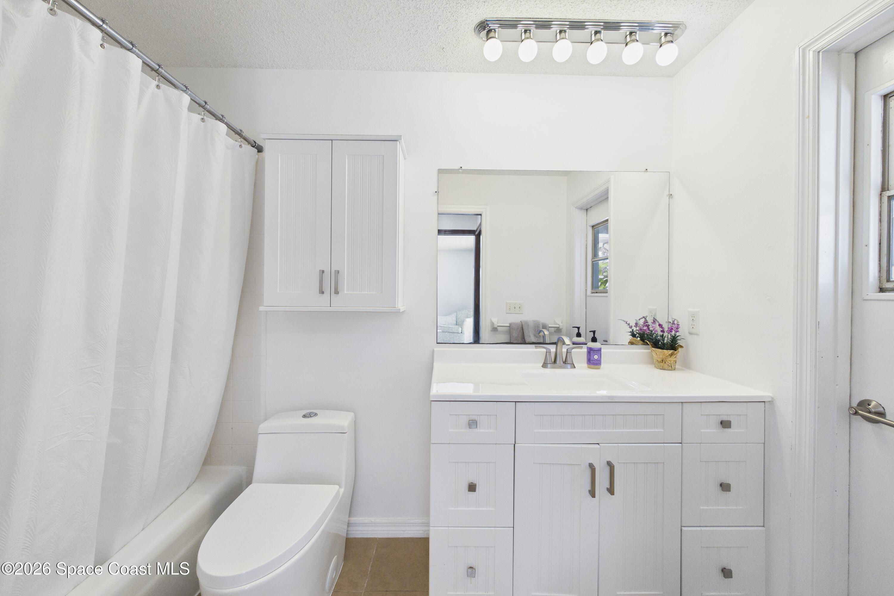 280 Coral Way West Indialantic, FL 32903 - Photo 37 of 72 a bathroom with a toilet a sink a vanity and mirror