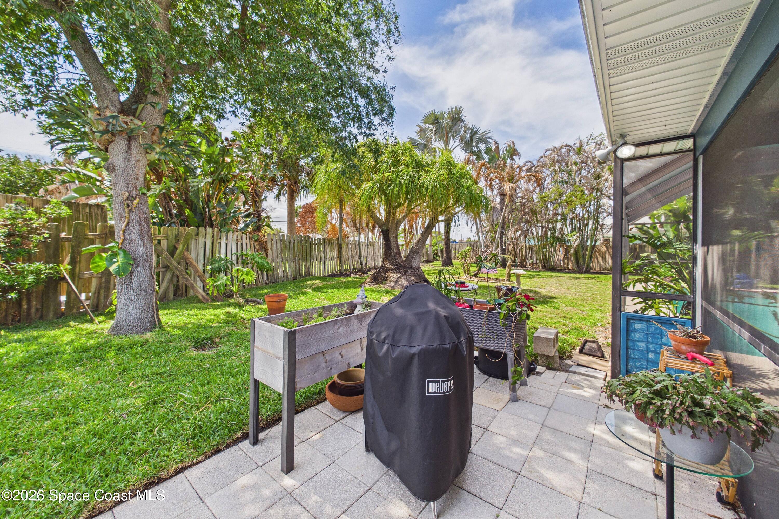 280 Coral Way West Indialantic, FL 32903 - Photo 53 of 72 a view of a patio with table and chairs potted plants and a large tree
