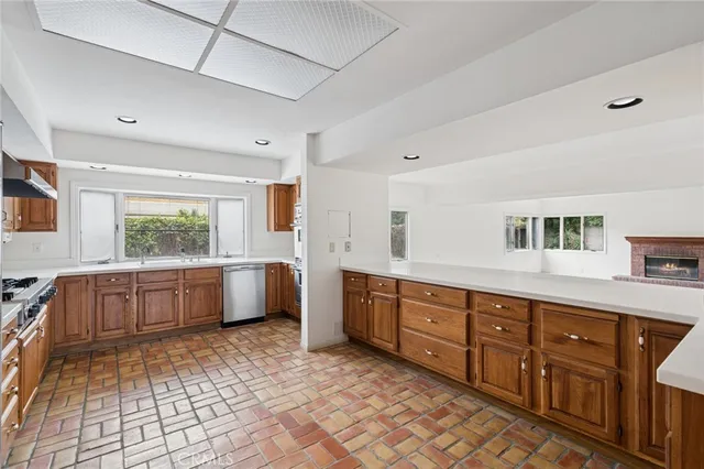 a large kitchen with stainless steel appliances granite countertop a sink and cabinets