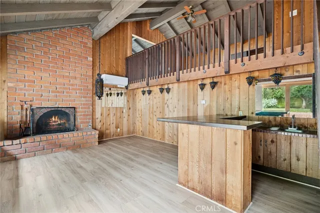 a view of a porch with wooden floor and a fireplace
