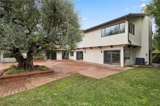 a view of a yard with plants and a bench
