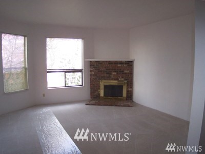 211 East 3rd Street Aberdeen, WA 98520 - Photo 11 of 27 an empty room with a fireplace and windows