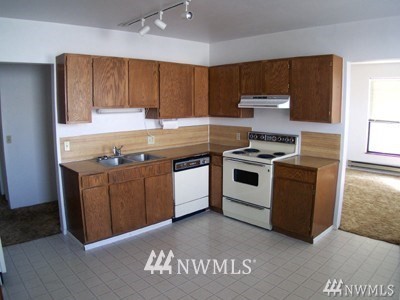 211 East 3rd Street Aberdeen, WA 98520 - Photo 14 of 27 a kitchen with stainless steel appliances granite countertop a stove a sink and a microwave
