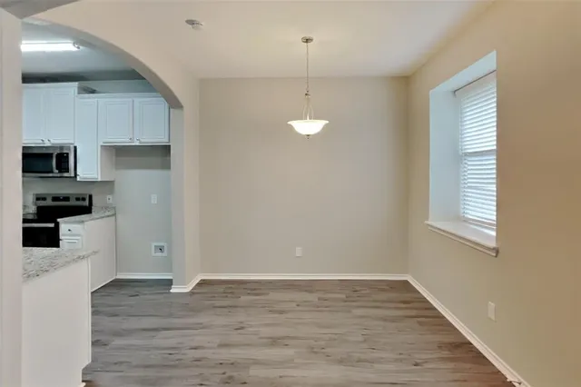 a kitchen with granite countertop a stove a sink and a refrigerator