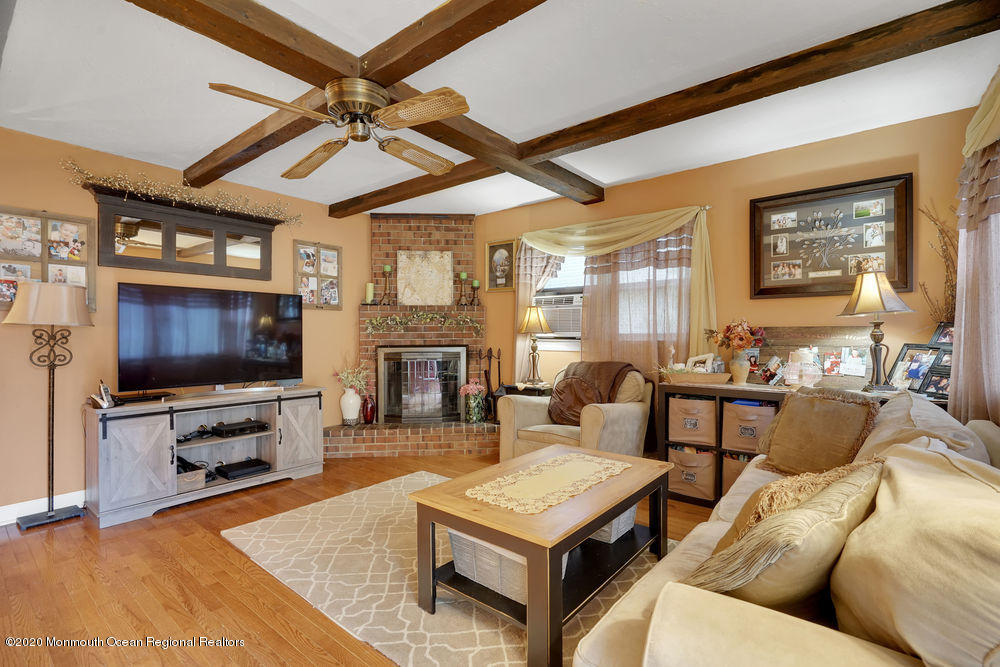223 Delaware Avenue Oakhurst, NJ 07755 - Photo 17 of 30 a living room with furniture a flat screen tv and a fireplace