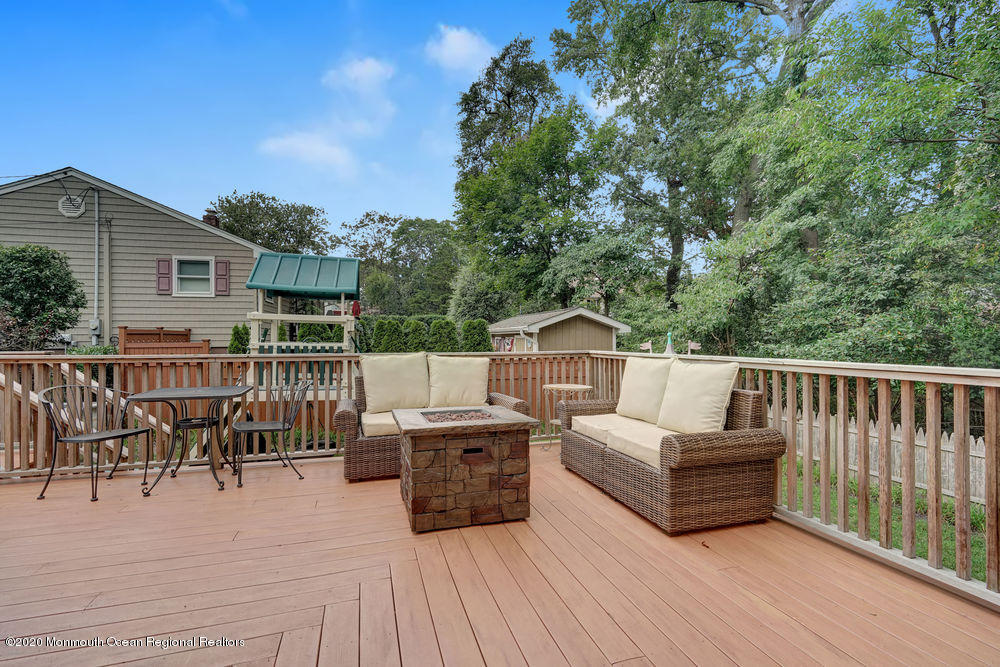 223 Delaware Avenue Oakhurst, NJ 07755 - Photo 21 of 30 a view of a patio with couches table and chairs with wooden floor and fence
