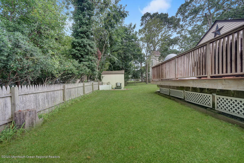 223 Delaware Avenue Oakhurst, NJ 07755 - Photo 25 of 30 a view of a backyard with wooden fence and large trees