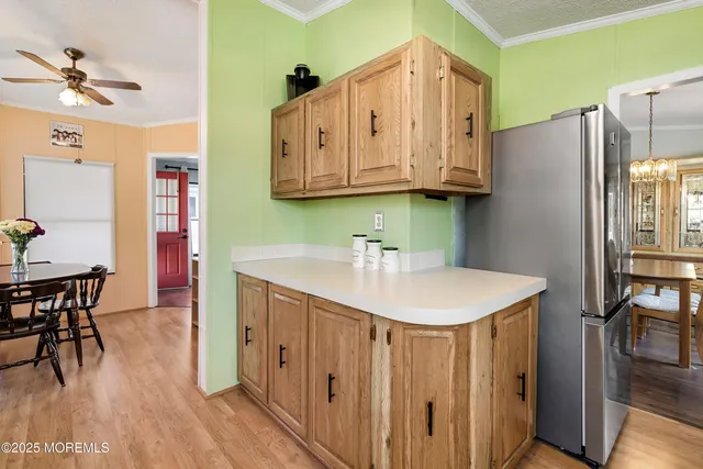 a kitchen with stainless steel appliances granite countertop a white refrigerator a sink dishwasher and a stove with wooden floor