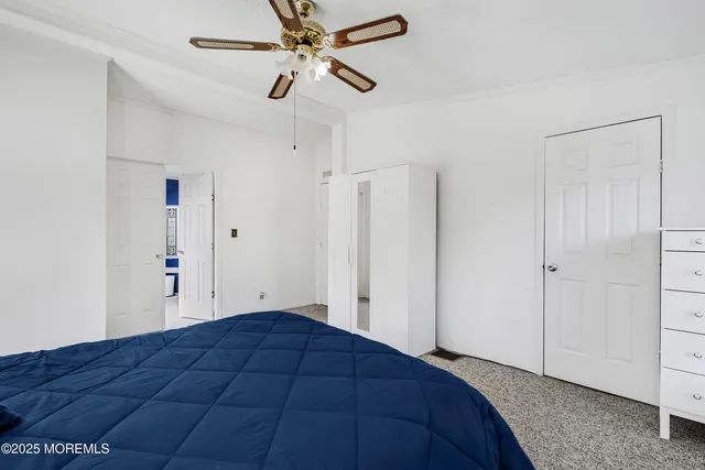 a bed room with a bed and a ceiling fan