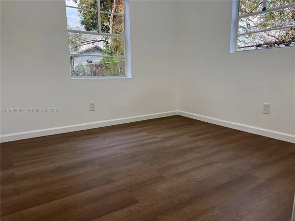 a view of a room that has wooden floor and window