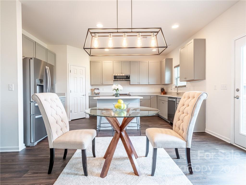 3 Henbit Way Arden, NC 28704 - Photo 23 of 46 a dining room with stainless steel appliances a dining table chairs and a refrigerator