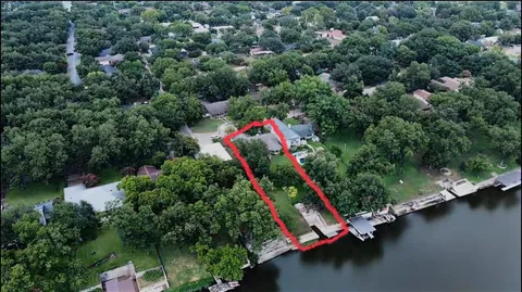 an aerial view of a house with a yard and lake view