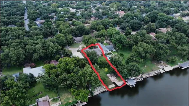 an aerial view of a house with a yard and lake view