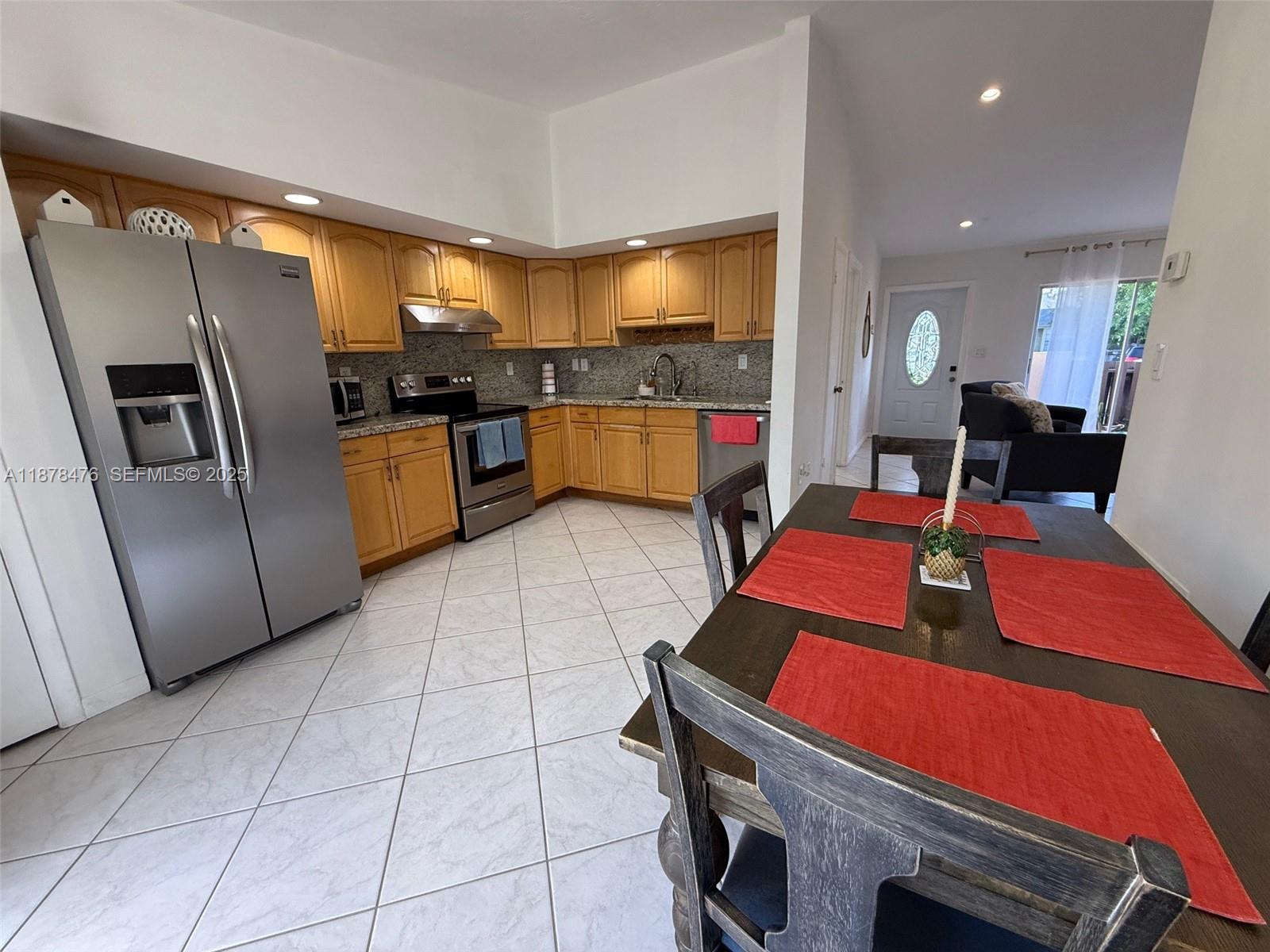 12413 Southwest 112th Terrace Miami, FL 33186 - Photo 6 of 16 a kitchen with kitchen island a counter top space a sink a refrigerator and cabinets