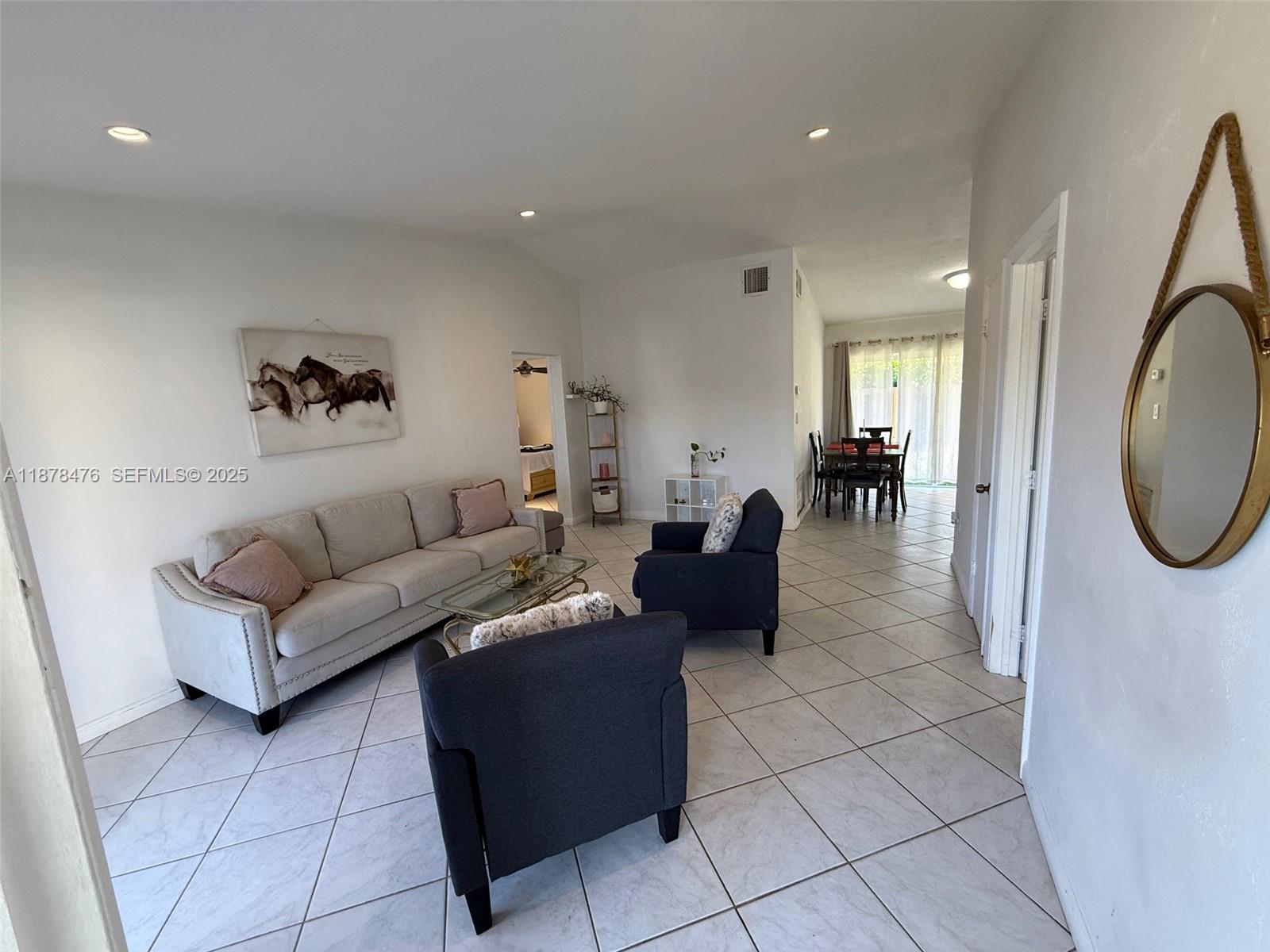 12413 Southwest 112th Terrace Miami, FL 33186 - Photo 10 of 16 a living room with furniture and a mirror