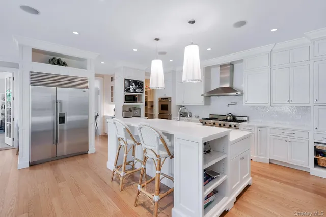 a kitchen with stainless steel appliances kitchen island granite countertop a stove a sink and a refrigerator