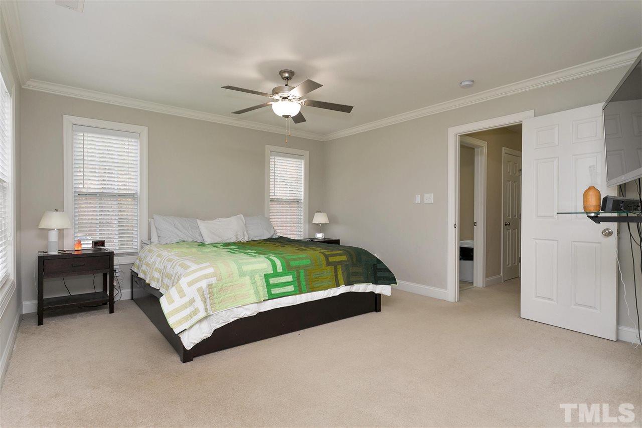 4630 Pat Reed Road Raleigh, NC 27616 - Photo 15 of 25 a bedroom with a bed and a chandelier
