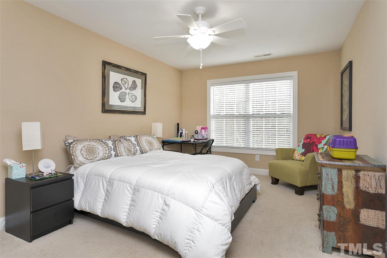 4630 Pat Reed Road Raleigh, NC 27616 - Photo 20 of 25 a bedroom with a bed and a chandelier