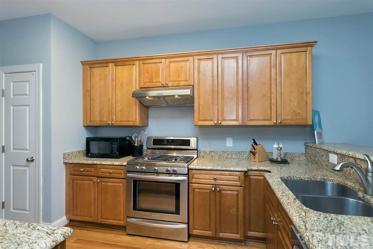 4630 Pat Reed Road Raleigh, NC 27616 - Photo 7 of 25 a kitchen with granite countertop a sink stainless steel appliances and cabinets