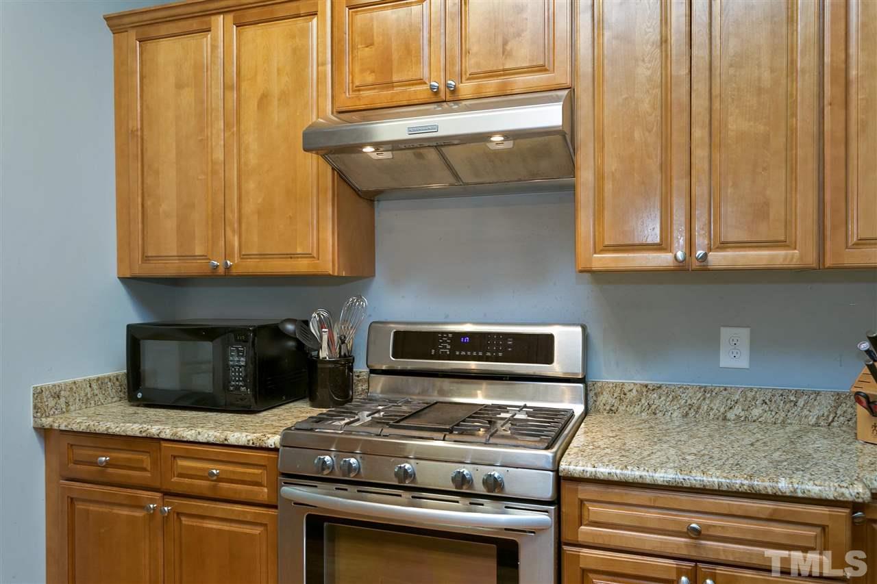 4630 Pat Reed Road Raleigh, NC 27616 - Photo 9 of 25 a kitchen with granite countertop wood cabinets and stainless steel appliances