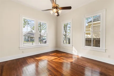 a view of an empty room with a window and wooden floor
