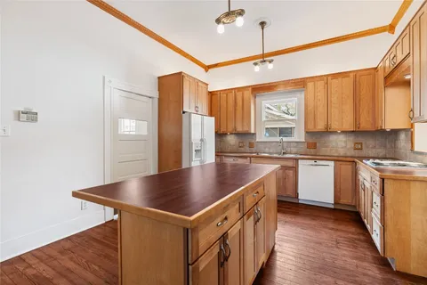 a kitchen with stainless steel appliances granite countertop a sink a stove and a refrigerator