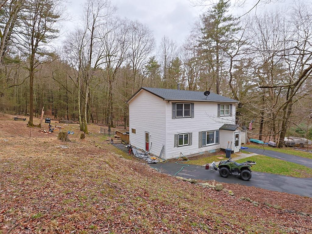 68 Kennel Road Cuddebackville, NY 12729 - Photo 3 of 21 a view of a white house with a large trees and playing area