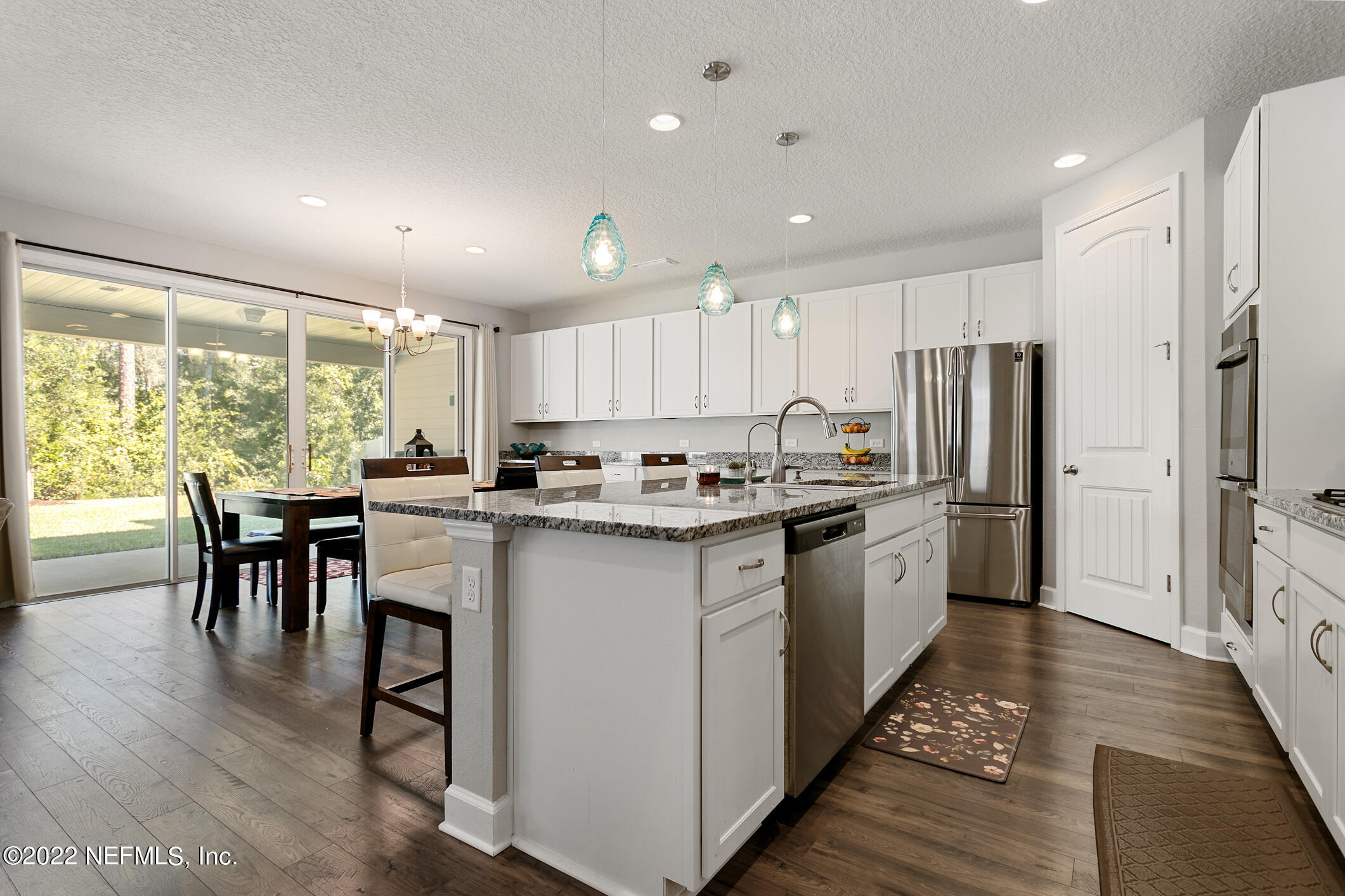 1098 Flach Drive St. Johns, FL 32259 - Photo 15 of 52 a kitchen with a table chairs refrigerator and microwave