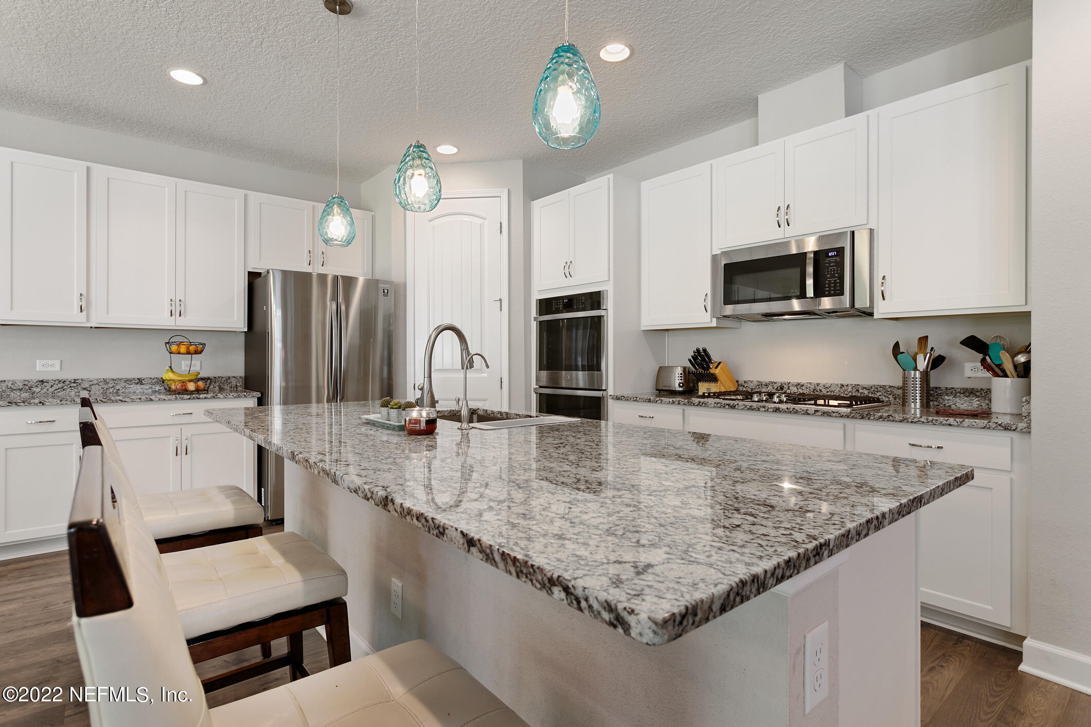 1098 Flach Drive St. Johns, FL 32259 - Photo 19 of 52 a kitchen with kitchen island granite countertop a sink counter space appliances and cabinets