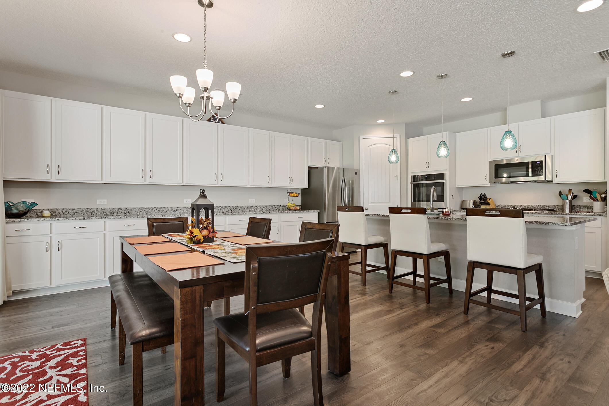 1098 Flach Drive St. Johns, FL 32259 - Photo 21 of 52 a kitchen with a dining table chairs stainless steel appliances and cabinets