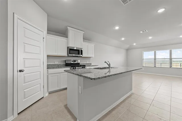 a kitchen with stainless steel appliances granite countertop a sink and a stove