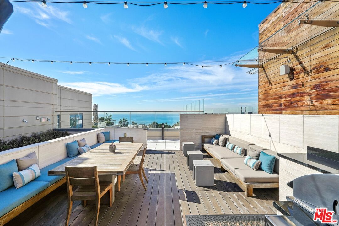 1755 Ocean Avenue, Unit 602 Santa Monica, CA 90401 - Photo 22 of 26 a balcony with wooden floor and outdoor seating