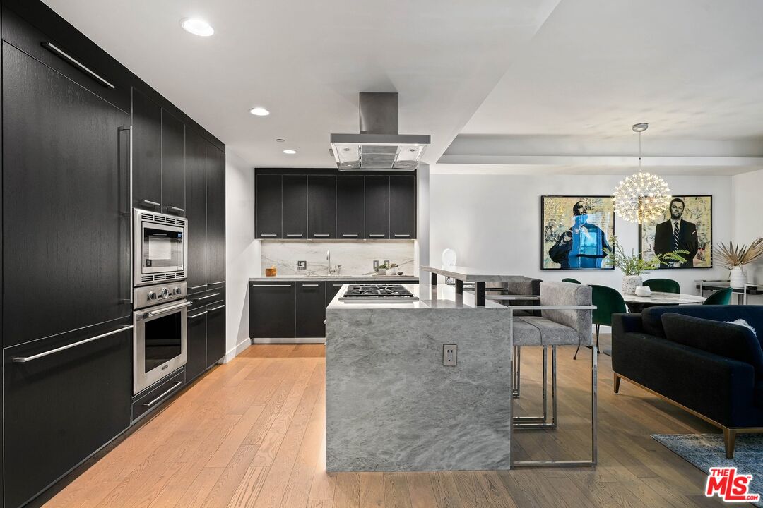 1755 Ocean Avenue, Unit 602 Santa Monica, CA 90401 - Photo 4 of 26 a large kitchen with stainless steel appliances wooden floor a stove and a sink