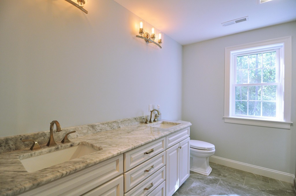 8 Maple Street Dunstable, MA 01827 - Photo 17 of 29 a bathroom with a granite countertop sink a toilet and a window