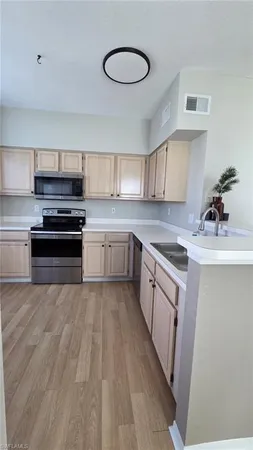 a kitchen with wooden cabinets and stainless steel appliances