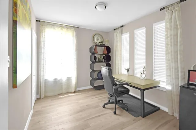 a view of a workspace with furniture and a window