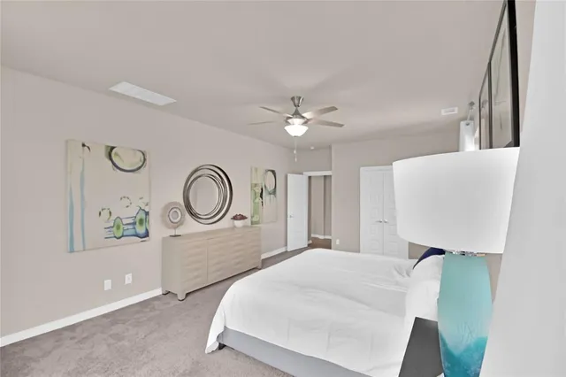 a bedroom with a large bed and a chandelier