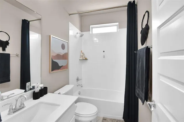 a bathroom with a bathtub shower sink vanity and toilet