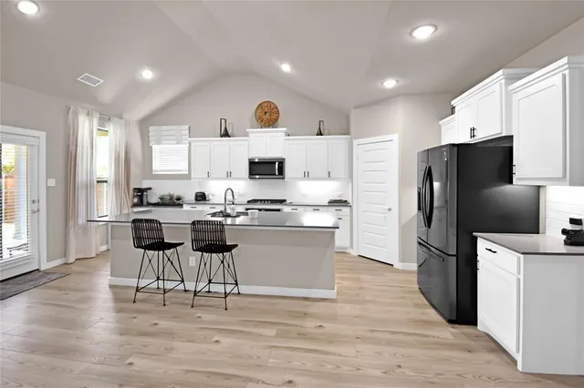a kitchen with a refrigerator a counter top space and cabinets