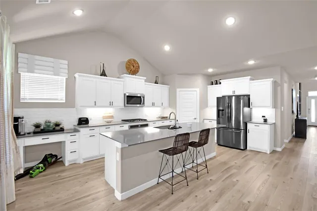 a kitchen with stainless steel appliances a stove a sink a refrigerator and cabinets