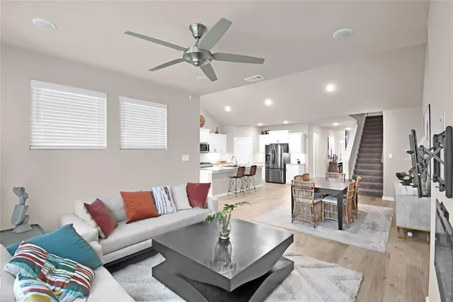 a living room with furniture kitchen view and a chandelier