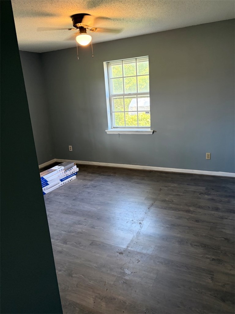 618 Madden Road Jacksonville, AR 72076 - Photo 22 of 34 Room featuring wood-finish flooring, a window with exterior views, and a ceiling fan with integrated lighting