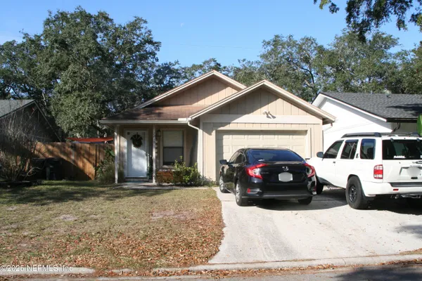 a view of a white house with a big yard and large trees
