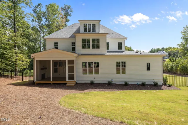 a view of a white house with a yard and a large tree