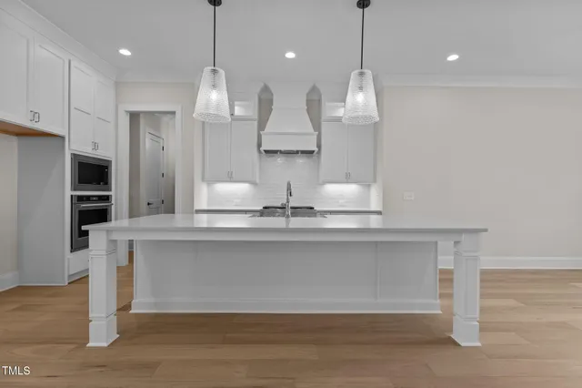 a large kitchen with granite countertop a stove a sink and a refrigerator