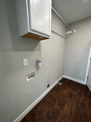 a view of a small space with wooden floor and a window