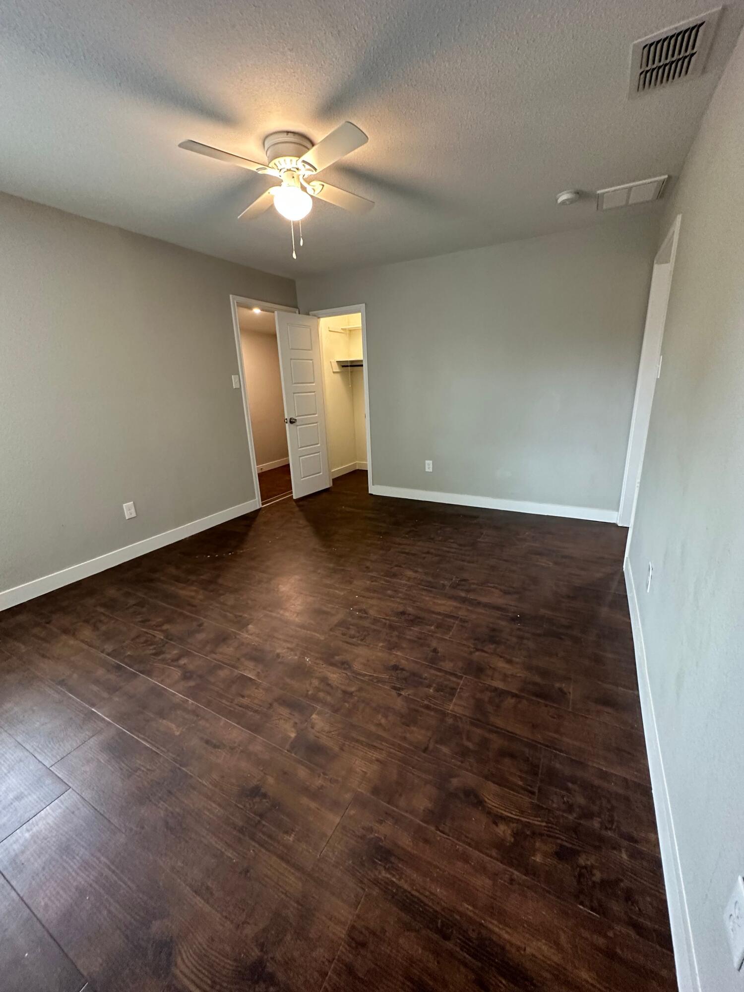 2824 35th Street, Unit A Lubbock, TX 79413 - Photo 5 of 16 an empty room with wooden floor and windows