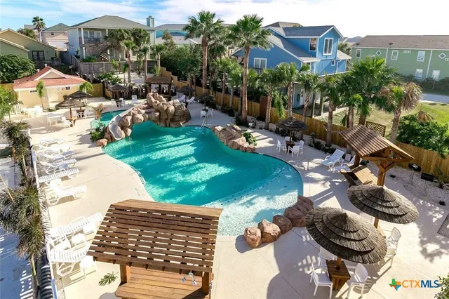 an aerial view of a house with a yard and lake view