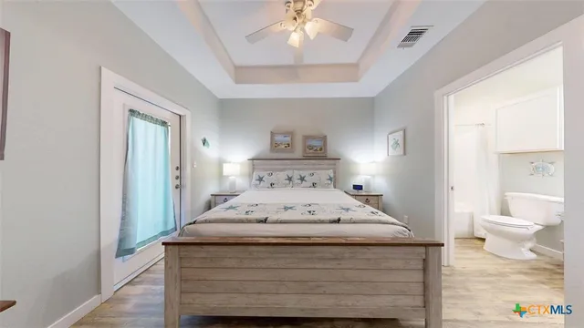 a spacious bedroom with a bed and a chandelier